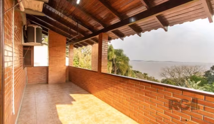 Ótima casa em tijolo á vista com 3 dormitórios, sendo 2 suítes, a suíte principal com hidro massagem, com sacada e linda vista para o lago Guaíba, banho social, living 2 ambientes em desnível com lare