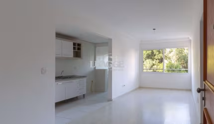Apartamento de dois dormitórios, uma suíte, living, cozinha com churrasqueira, área de serviço, banheiro social e uma vaga de garagem.