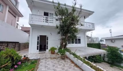 Locação em Coqueiros! Casa com 4 suítes, churrasqueira e 5 vagas de garagem.