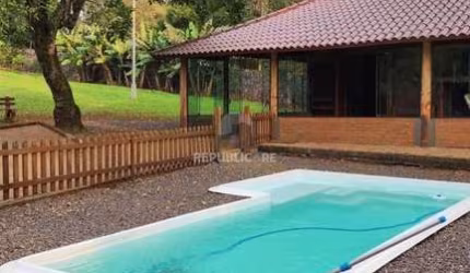 Casa com 2 dormitórios, piscina em terreno totalmente arborizado.
