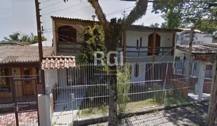 Casa com dois pavimentos, quatro dormitórios, sendo um suíte com hidromassagem, sacada em toda extensão da frente, amplo living com três ambientes, lareira, banheiro social, lavabo, belíssima escada d