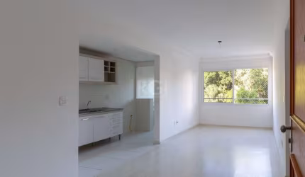 Apartamento de dois dormitórios, uma suíte, living, cozinha com churrasqueira, área de serviço, banheiro social e uma vaga de garagem.