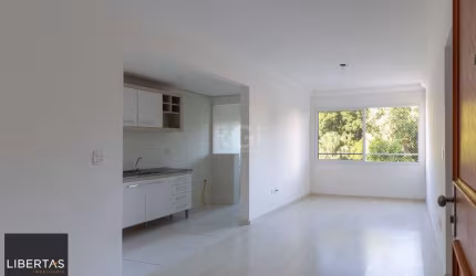 Apartamento de dois dormitórios, uma suíte, living, cozinha com churrasqueira, área de serviço, banheiro social e uma vaga de garagem.