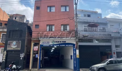 Prédio residencial de 2 andares com 4 apartamentos e um comércio no térreo.