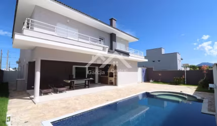 Sobrado de alto padrão em condomínio fechado em Peruíbe com 4 suítes e área de lazer com piscina
