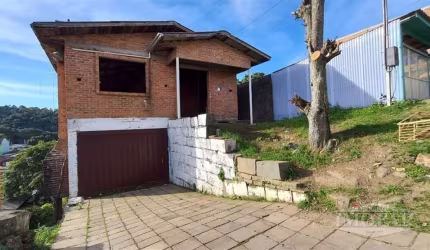 Casa de alvenaria, localizada no bairro Primeiro de Maio, com 3 pisos. Apenas o andar do meio está concluído, possui 2 dormitórios, sala, cozinha, banheiro social, área de serviço e garagem.  Área pri