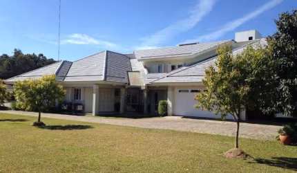 Excelente casa em condomínio fechado sendo 02 terrenos de 1.000,00m cada.  Casa com 04 dormitórios (sendo 02 suítes master com closet), ampla sala para 03 ambientes com lareira, escritório, copa/cozin