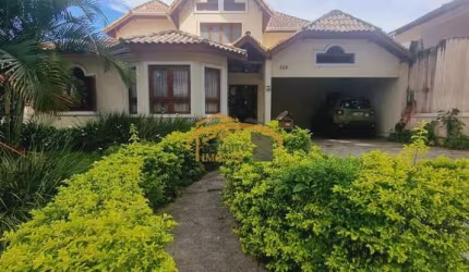 Casa térrea em condomínio fechado, Nova Higienópolis, com 3 suítes, 4 vagas de garagem, quintal com churrasqueira e piscina.