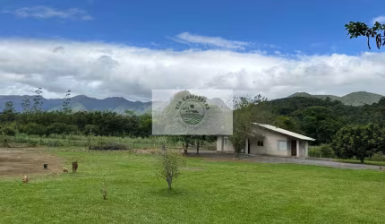 Sítio com 22.000 m², com duas casas, riacho cristalino, escriturada, frente para rua pavimentada