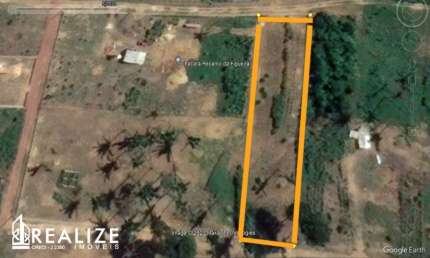 Lote cercado, com mureta, mourões e arame em três lados.