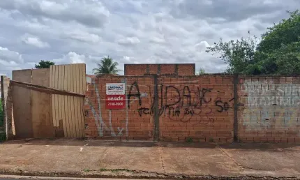 Terreno murado com água e luz ligados em rua de grande movimento