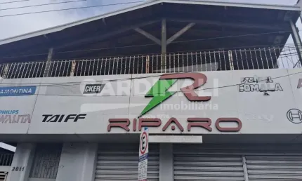 Salão no centro da cidade, com uma casa grande no piso superior.