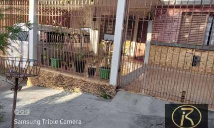 Garagem coberta para 2 carros (aproximadamente 6x6m).  Pequeno jardim ou área de circulação.    2. Casa principal (10x20m):  Sala de estar e jantar in