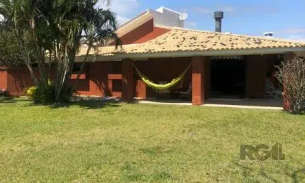 Espaçosa e acolhedora residência numas das esquinas em charmosa rua de atlântida, com imenso jardim, paisagismo, lareira,4 dormitórios, sendo duas suítes.
