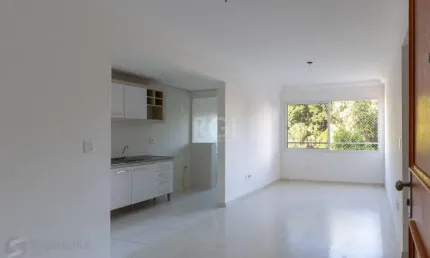 Apartamento de dois dormitórios, uma suíte, living, cozinha com churrasqueira, área de serviço, banheiro social e uma vaga de garagem.