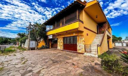 Casa com 2 salas comerciais, 3 quartos, vaga de garagem churrasqueira, suíte, no bairro Cavalhada, Porto Alegre/RS