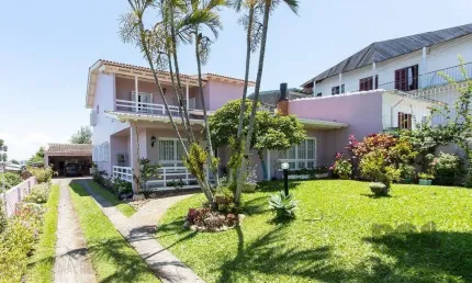 Casa com 4 quartos, suíte, churrasqueira, lareira, garagem coberta e lindo jardim.