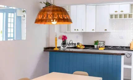Uma casinha branca de varanda e um jardim de gerânios para colorir os dias