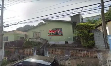 Terreno com generosos 303 m², acompanhado por uma casa antiga, em um terreno em aclive.
