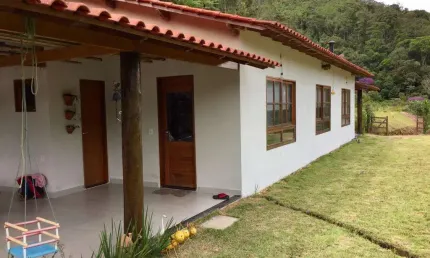 Sitio com ampla casa térrea com varanda ampla lateral.