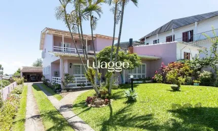 Casa com 4 quartos, suíte, churrasqueira, lareira, garagem coberta e lindo jardim.
