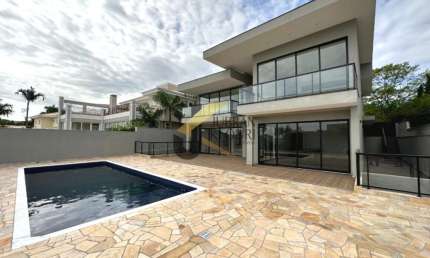 Casa à venda no Alphaville Campinas, com 4 suítes, lazer comum e garagem para vários carros.