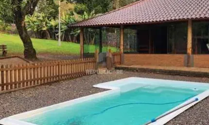 Casa com 2 dormitórios, piscina em terreno totalmente arborizado.