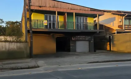 Sobrado com sala comercial e dois apartamentos com três e dois quartos.