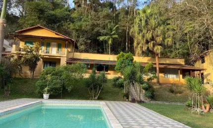 Casa com 05 quartos e três suítes, churrasqueira, piscina e quadra, em um terreno de 3027 m2.