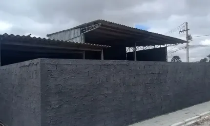 Terreno com um barracão comercial  e uma casa de alvenaria.
