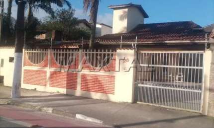Casa à venda em Bertioga na Rua Oswaldo Cruz,  à 700 metros da praia,  com 3 suítes e 4 vagas.