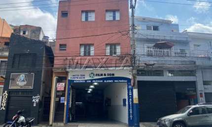 Prédio residencial de 2 andares com 4 apartamentos e um comércio no térreo.