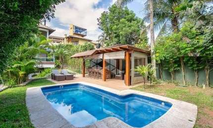 Casa com vista parcial para o mar de 4 dormitórios, sendo 4 suítes, 3 vagas de garagem na Praia Mole em Florianópolis/SC.