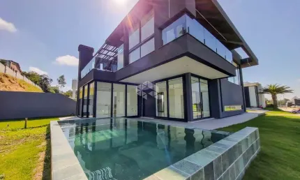 Casa de alto padrão nova no condomínio fechado Reservas do Lago em Nova Santa Rita. Terreno de esquina com 504m², 4 dormitórios, sendo 2 suítes.