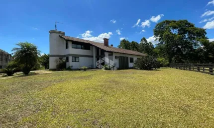 Área de terras com casa de 04 dormitórios e galpão/pavilhão.