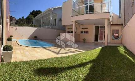 Casa diferenciada no bairro Nonoai, 4 domitórios com ar condicionado, sendo 1 suíte master com closet, 3 vagas de garagem, pátio e piscina.