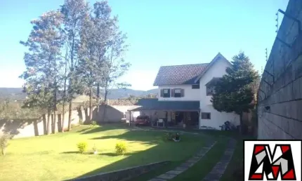 Casa com amplo quintal e gramado, tipo chalé, várias vagas de garagem.