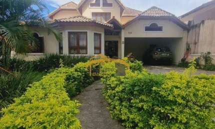 Casa térrea em condomínio fechado, Nova Higienópolis, com 3 suítes, 4 vagas de garagem, quintal com churrasqueira e piscina.