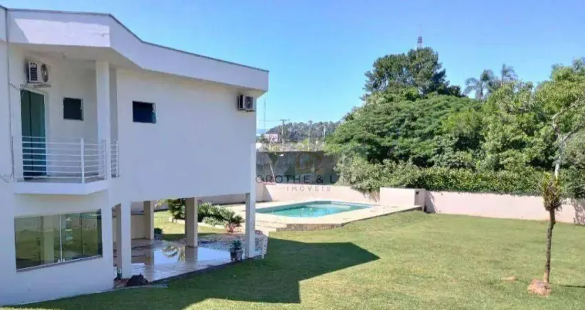 Residência de alto padrão com piscina e área de lazer em terreno generoso.
