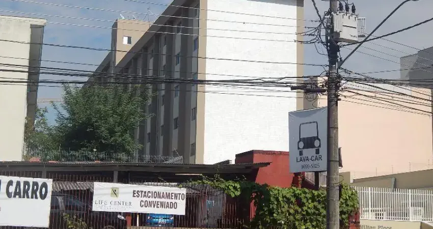 Apartamento duplex com cozinha com armários e quarto de solteiro com armário e cama.