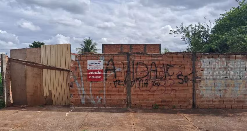Terreno murado com água e luz ligados em rua de grande movimento