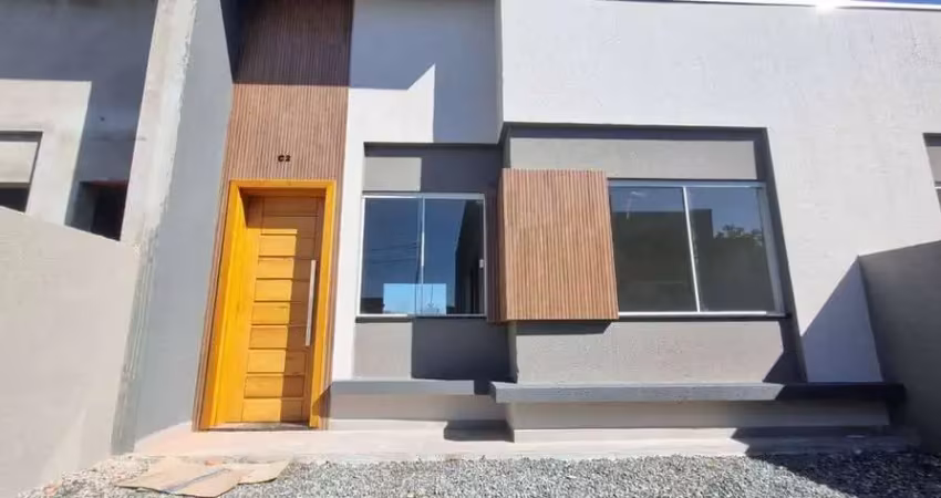 Casa nova com 2 dormitórios/ 1bwc social, 2 vagas garagem, amplo espaço de terreno na frente, em itapoá/sc.