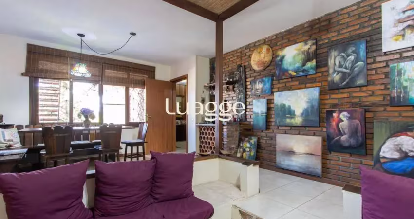 Casa de alvenaria, possui 3 dormitórios, uma suíte, hall de entrada, lavabo, living com lareira, cozinha ampla com armários, área gourmet com churrasqueira, corredor, pátio e 4 vagas de garagem, uma c