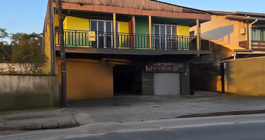 Sobrado com sala comercial e dois apartamentos com três e dois quartos.