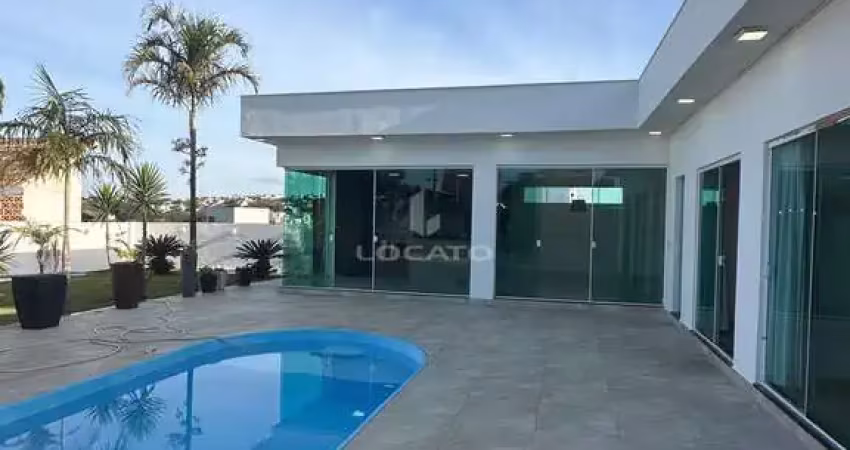 Casa em condomínio fechado com portaria 24 horas, piscina e grande área descoberta verde gramada.