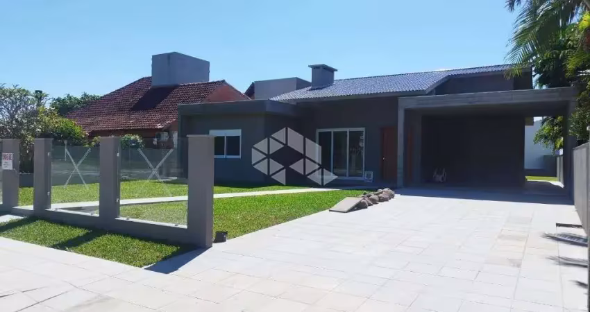 Casa térrea com 4 suítes + lavabo, amplo living com lareira e com acesso ao pátio em frente, quanto aos fundos da casa, em atlântida/rs.