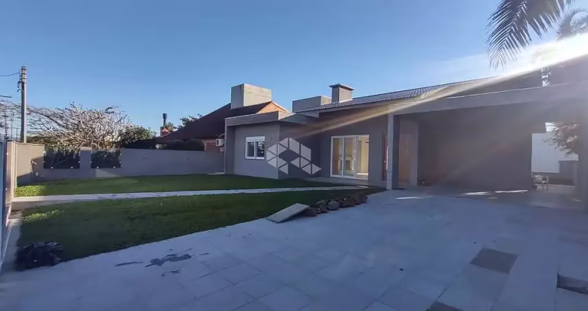 Casa térrea com 4 suítes + lavabo, amplo living com lareira e com acesso ao pátio em frente, quanto aos fundos da casa, em atlântida/rs.