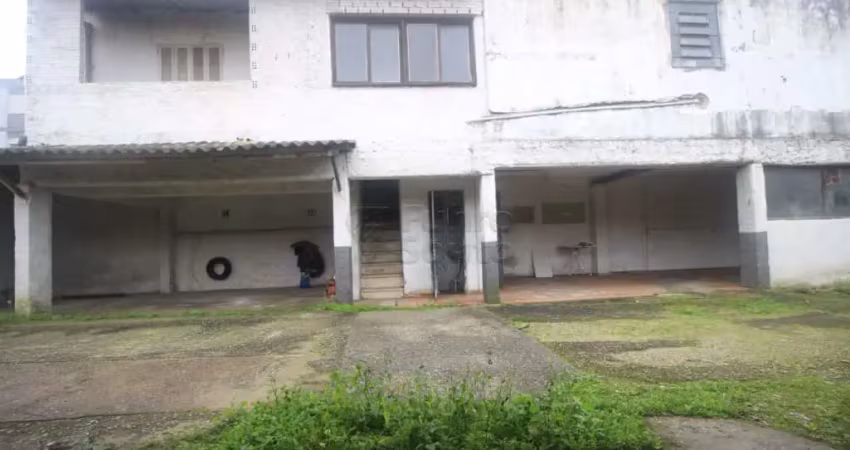 Prédio comercial com 22 boxes e casa residencial ideal para estacionamento e moradia.